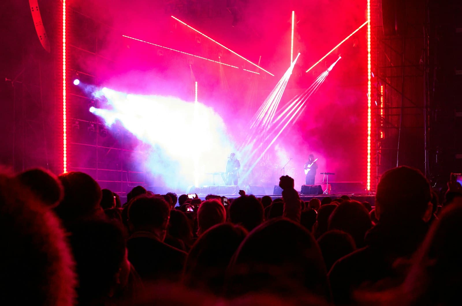 The view from inside a crowd looking at a brightly lit stage